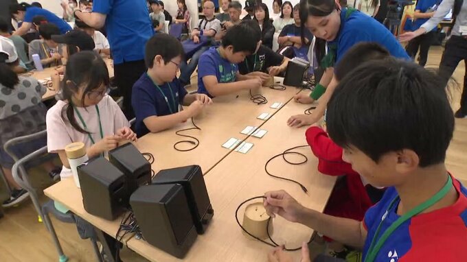 最先端技術を楽しく学ぶイベントで「光糸電話」の工作に挑戦する子どもたち
