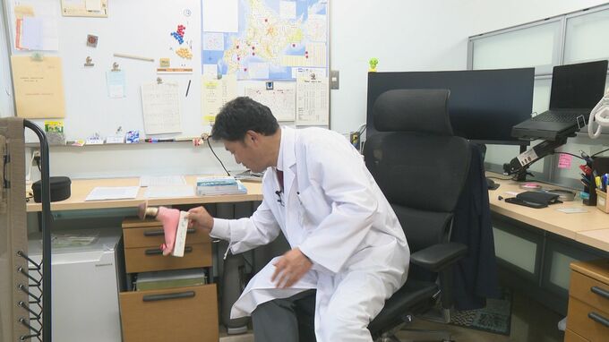 引き出しからトロフィーを取り出す高原幹教授