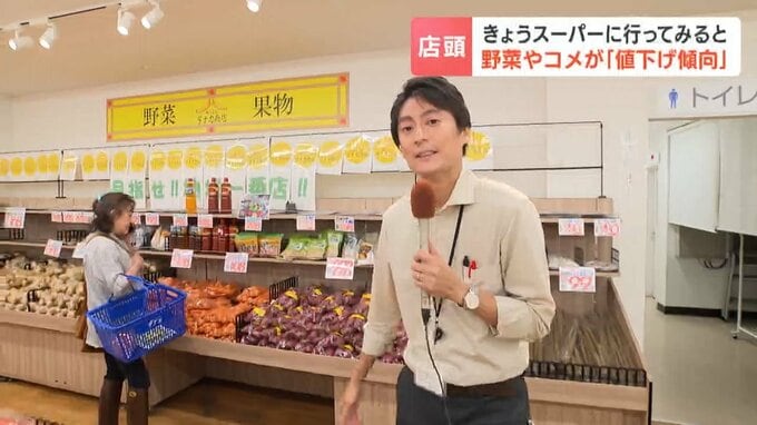 スーパーの青果コーナーの前でリポートする高橋智也記者