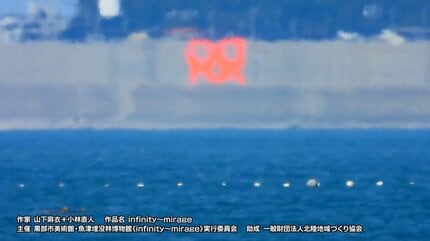 海に浮かぶ「m」のマークは何かのサイン？ 8キロ離れた対岸から鑑賞