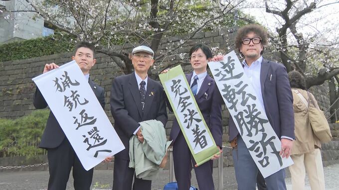最高裁判決後に弁護団と並ぶ池上治男さん（3月）