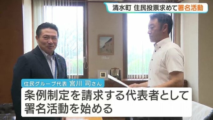 清水町役場で辻町長から条例制定請求代表者の証明書を手渡される住民グループ代表の宮川司さん