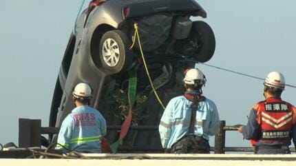 高齢ドライバー運転の車が駐車場の柵を突き破り転落 木に垂直に