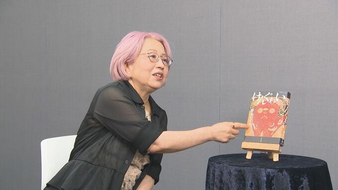 直木賞受賞作「けんぐゎい」を指さす朝倉かすみさん