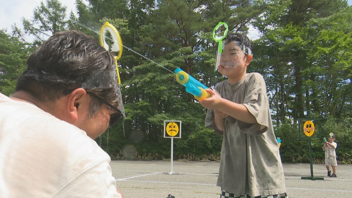 夏の暑さを吹き飛ばす　家族や友人らで水鉄砲打ち合う　清里丘の公園夏祭り　山梨