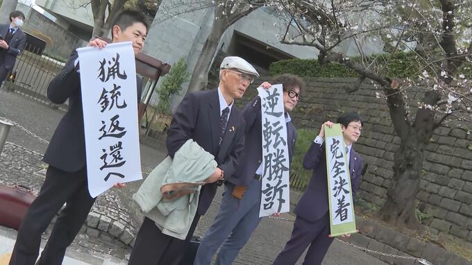 最高裁判決後に弁護団と並ぶ池上治男さん（77）