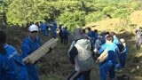 バケツリレー方式に約150人が井桁の資材を斜面に上げる 平泉町で大文字送り火の火床づくり|TBS NEWS DIG