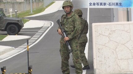 本土のマスコミは信用していない。笑ってるね、このおっさん」全身写真