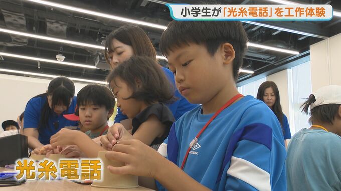 「光糸電話」の工作体験会に参加する小学生たち