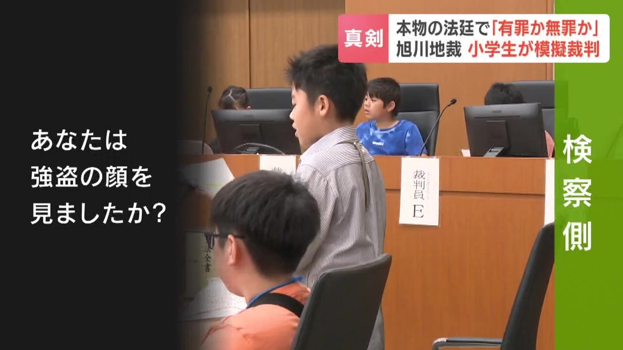 銀行員役に質問する検察官役の小学生