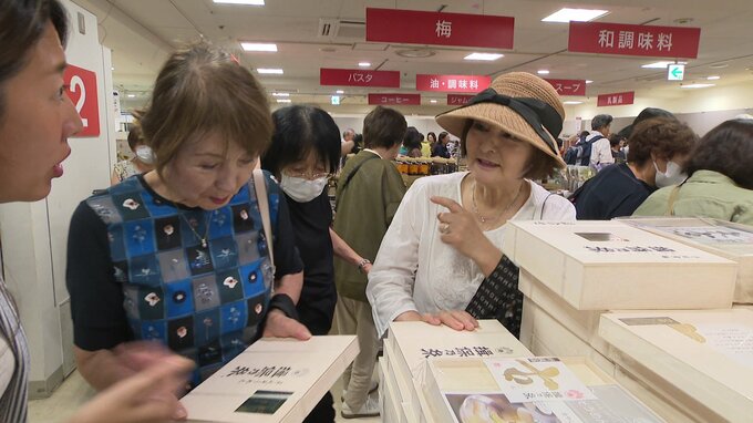 木箱に入ったそうめんを手にとり選ぶ客