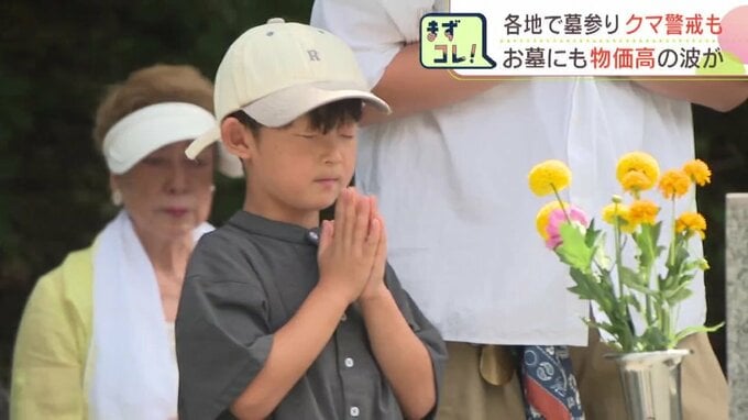 墓の前で手を合わせる子ども